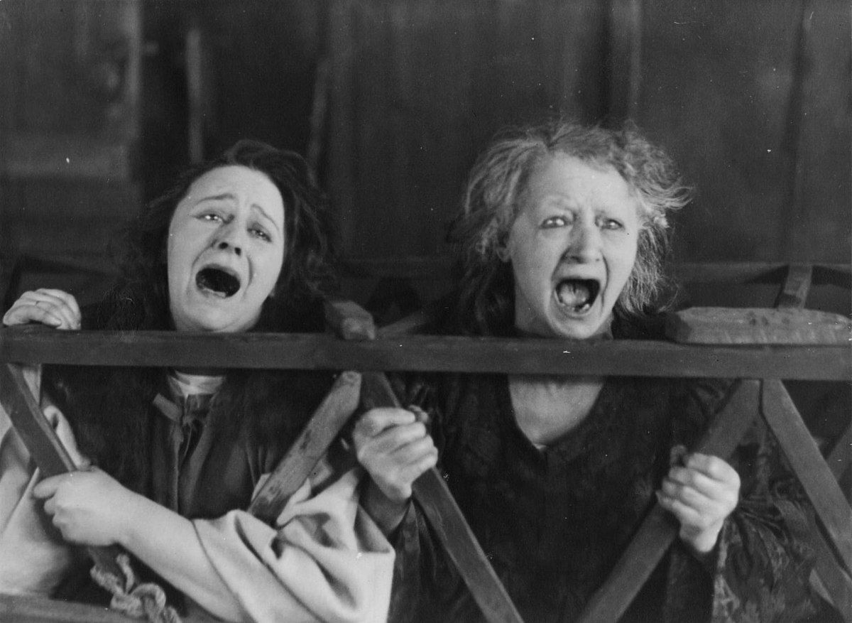 Still from the 1922 film Häxan depicting two accused witches screaming.
