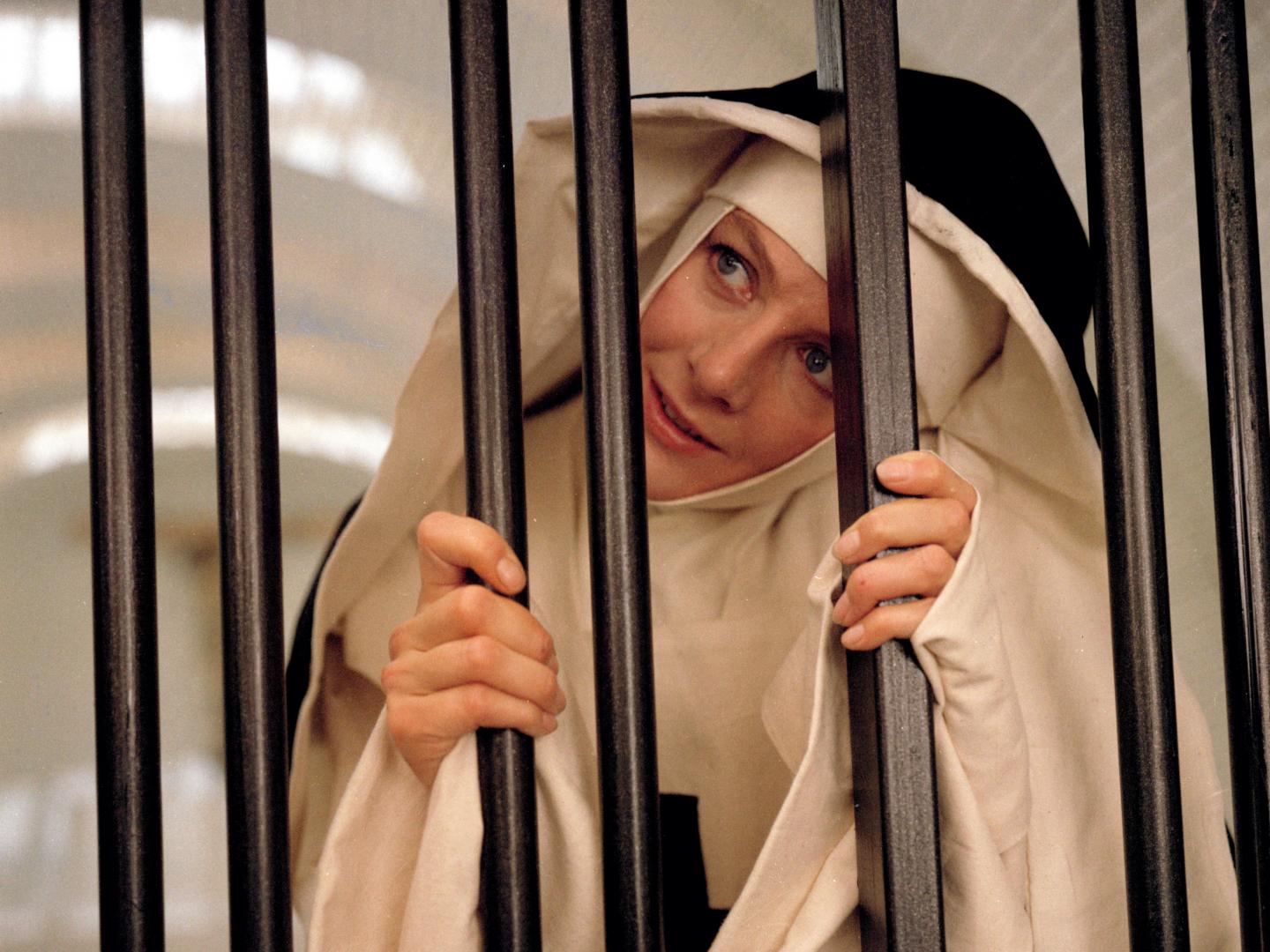 Still from the 1971 film The Devils depicting actor Vanessa Redgrave in a nun's habit looking out from behind bars.